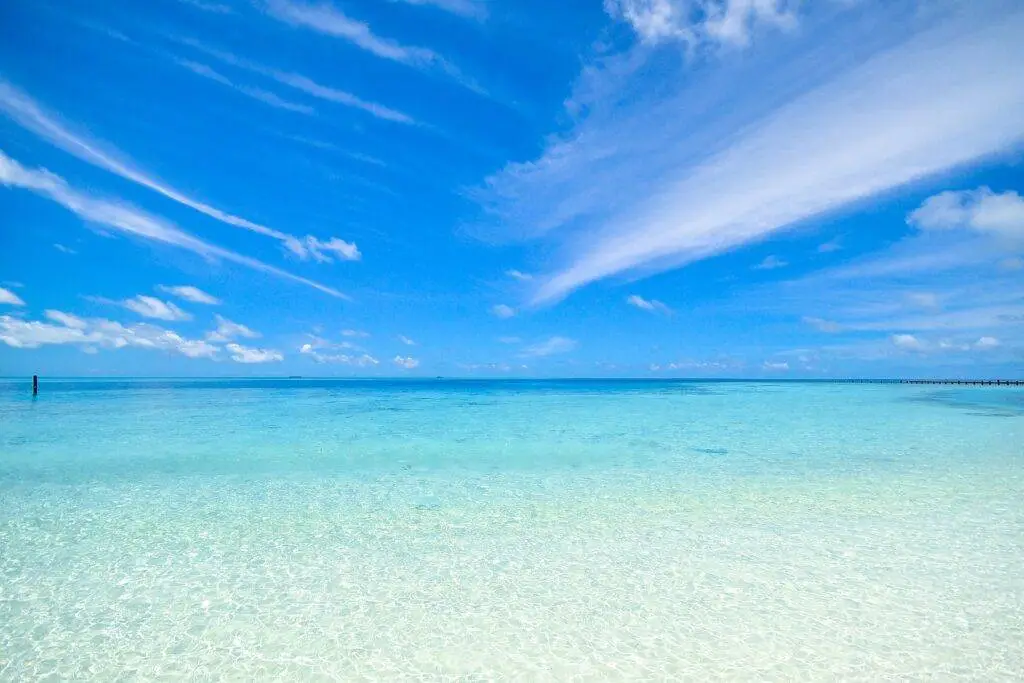 beach scene with shallow clear water and blue skies